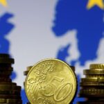 FILE PHOTO: Euro coins are seen in front of displayed flag and map of European Union in this picture illustration taken in Zenica